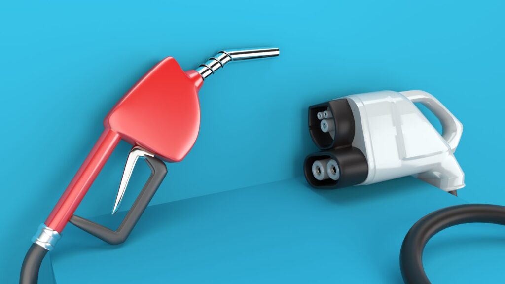 A vivid blue background with a traditional red gas pump handle on the left side and a white electric charger handle on the right side. 